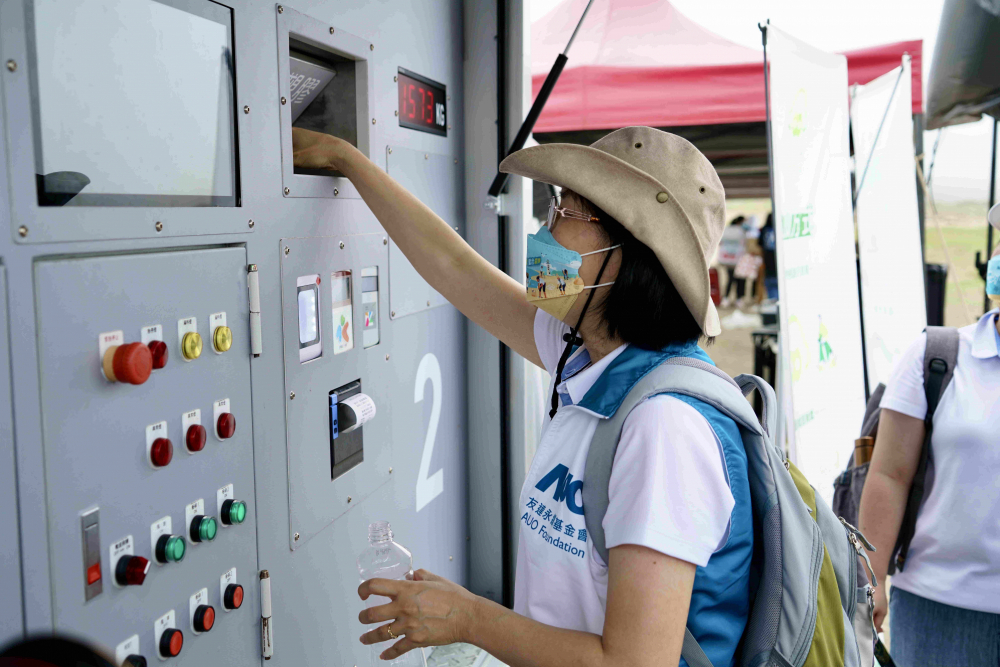 志工們將拾起的寶特瓶投入「好歸塑專車」，讓廢棄塑料空瓶可以直接粉碎、縮小體積，未來將可再製成購物袋、寶特衣、悠遊卡等生活用品